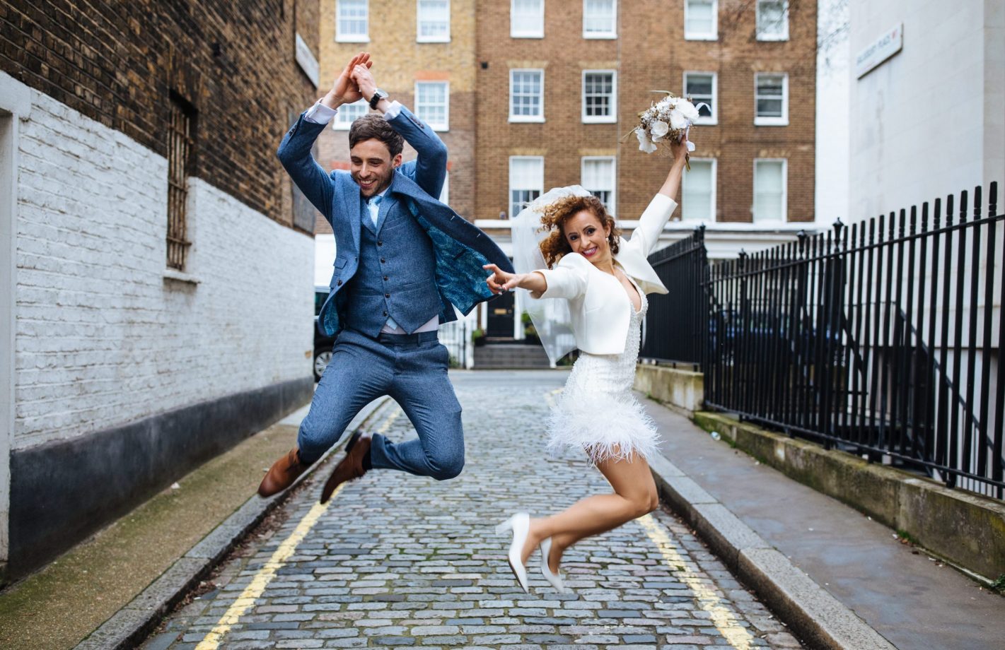 bride and groom jumping for joy at Marylebone town hall wedding