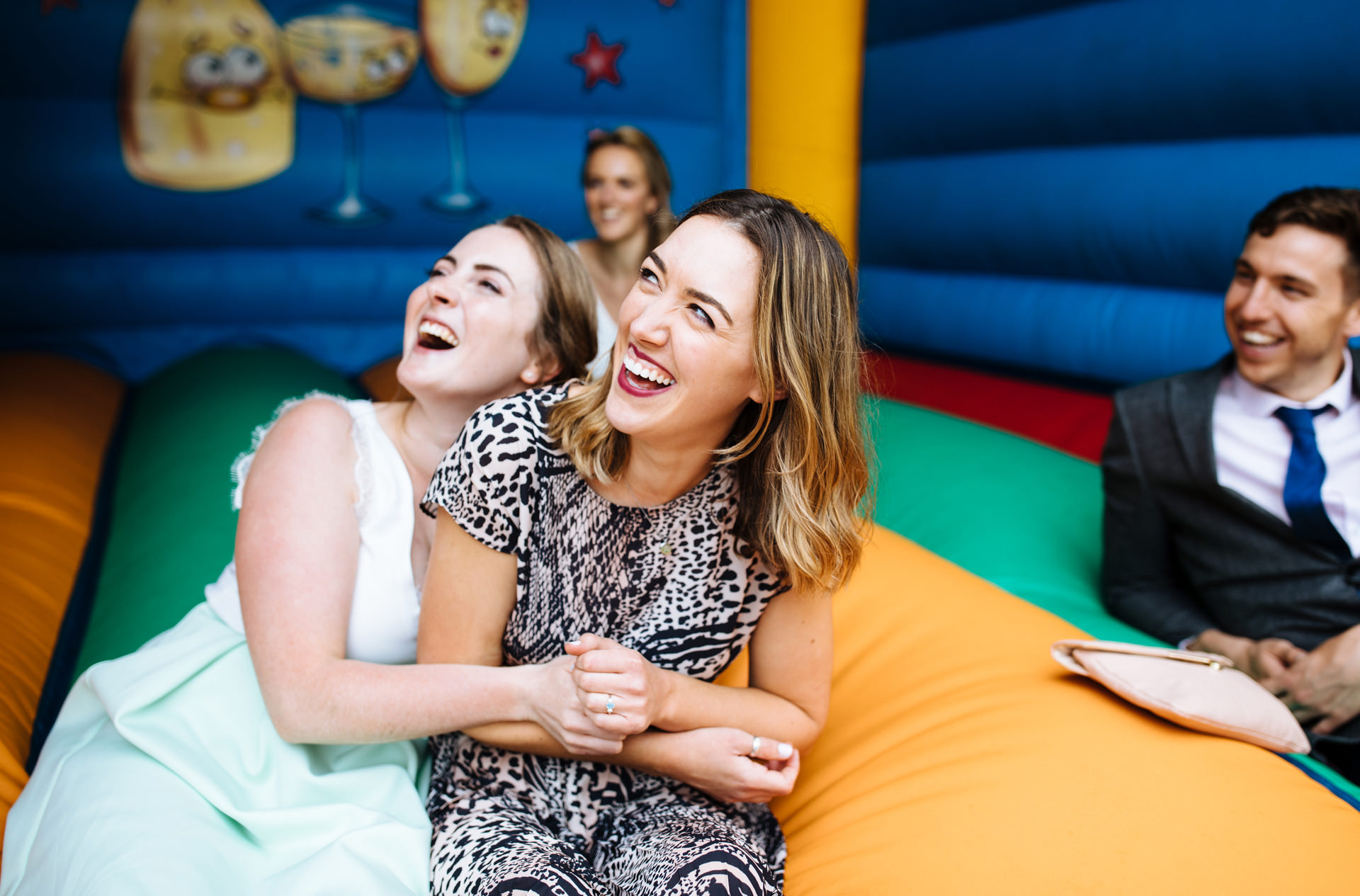 wedding guests laughing on bouncy castle