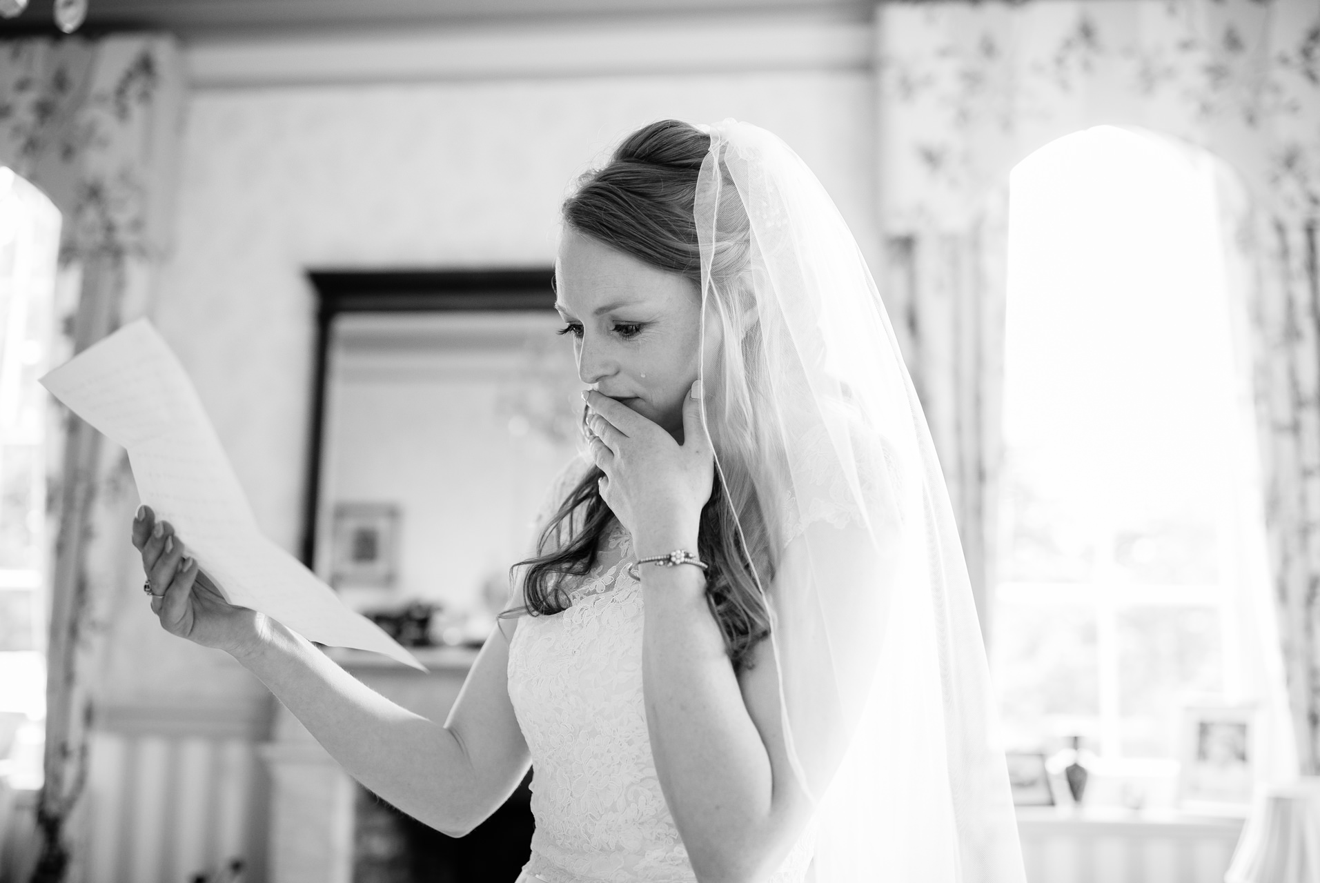 bride crying a tear reading letter from husband to be on wedding morning